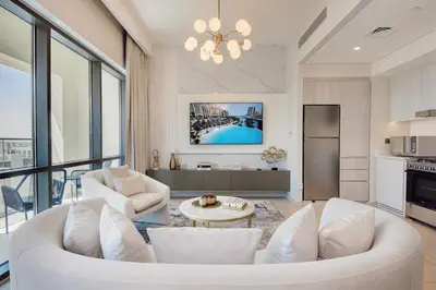 a living room with a white couch and a table at Modern 2BR Apartment - Vida Residences Creek Beach - Creek Beach Access in Dubai