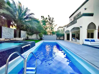 a swimming pool in front of a house at Signature 7-bedroom Villa Marina in Dubai