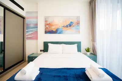 a bedroom with a large bed and a painting on the wall at Cozy NEW brand 1BR at JVC Binghatti Corner in Dubai