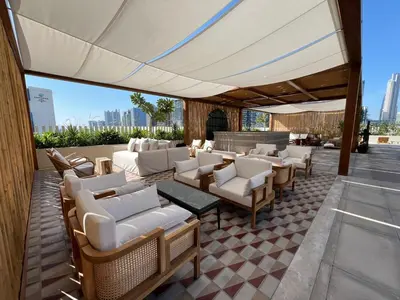 a patio with white chairs and tables and a white umbrella at THE UPSIDE Downtown Dubai in Dubai