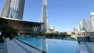 a large swimming pool in a city with tall buildings at Grande Signature by Emaar! Amazing Pool, Gym and Location! in Dubai