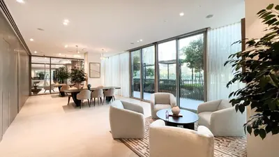 a living room with chairs and tables and windows at Grande Signature by Emaar! Amazing Pool, Gym and Location! in Dubai