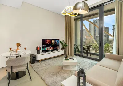 a living room with a couch and a tv at Cozy 1BR The Address JBR in Dubai