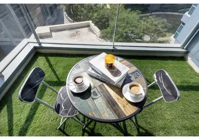 a table with a cup of coffee and two chairs at Luxe Vista - Top Location Dubai Marina 1BR - Metro and Beach Access in Dubai