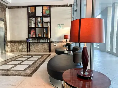 a lobby with a chair and a table and a lamp at Luxe Vista - Top Location Dubai Marina 1BR - Metro and Beach Access in Dubai
