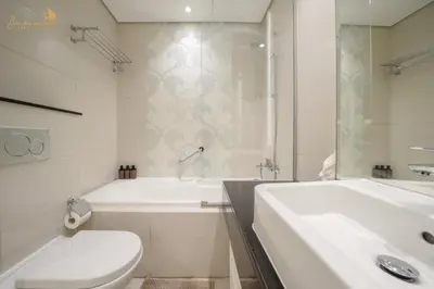 a bathroom with a tub and a toilet and a sink at Cozy Canal View Studio in Dubai