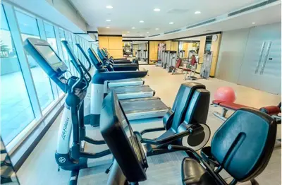 a gym with a row of cardio machines at Cozy Canal View Studio in Dubai