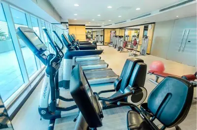 a gym with rows of exercise bikes in a row at Cozy Canal View Studio in Dubai