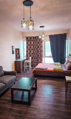 a living room with a couch and a table at Upgraded Studio In Dubai Marina in Dubai
