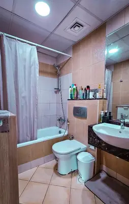 a bathroom with a toilet and a sink and a tub at Upgraded Studio In Dubai Marina in Dubai