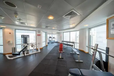 a gym with treadmills and machines in a building at Homes & Beyond l 2BR in the Heart of Dubai Marina in Dubai
