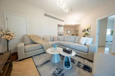 a living room with a couch and a table at Homes & Beyond l 2BR in the Heart of Dubai Marina in Dubai