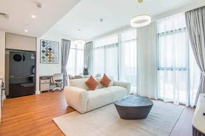 a living room with a couch and a table at Brand New Stylish 2 BR with Balcony in Dubai