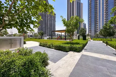 a park in a city with tall buildings at Brand New Stylish 2 BR with Balcony in Dubai