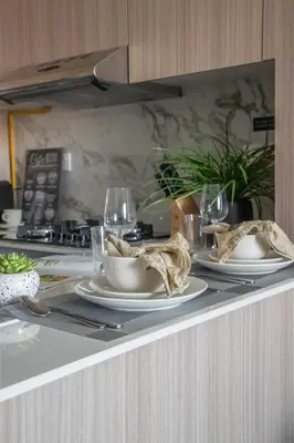 a table with plates and wine glasses on a counter at Frank Porter - Bali Residences in Dubai