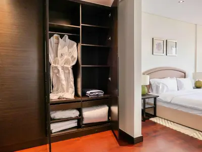 a bedroom with a closet with towels and a bed at Oceanfront 2BR Apartment with Perfect Views in Dubai