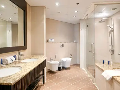a bathroom with two sinks and a shower and a toilet at Oceanfront 2BR Apartment with Perfect Views in Dubai