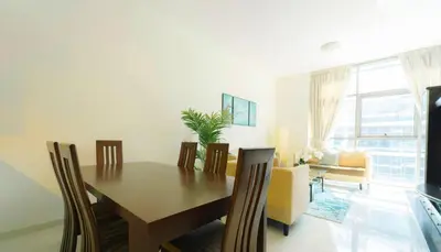 a dining room with a wooden table and chairs at AWS Holiday Homes - Charming stay near Golf Course in Dubai