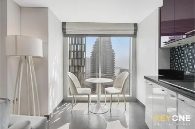a kitchen with a table and chairs and a large window at Cayan Escape Lavish 1BR with Sea View in Dubai