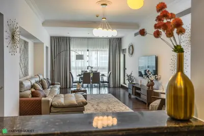 a living room and dining room with a vase of flowers at Clever Guest 030 Golden Mile 6 in Dubai