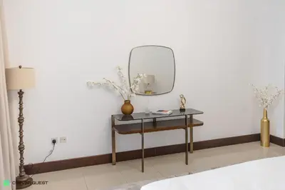 a dressing table with a mirror on a white wall at Clever Guest 030 Golden Mile 6 in Dubai