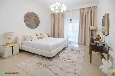a white bedroom with a bed and a table at Clever Guest 030 Golden Mile 6 in Dubai
