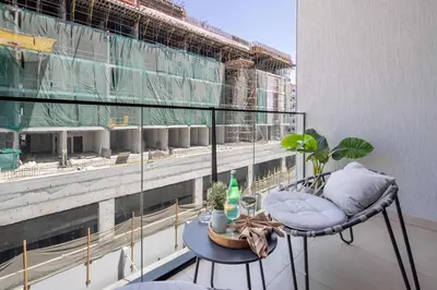 a balcony with a chair and a table on a building at Frank Porter - MYKA Residence in Dubai