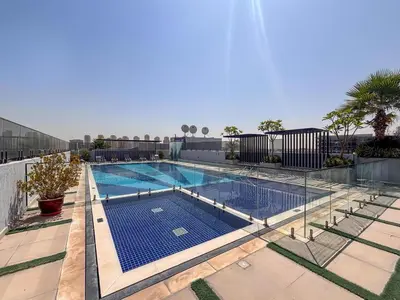 a large swimming pool with a fence around it at Frank Porter - MYKA Residence in Dubai