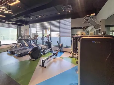 a gym with treadmills and exercise bikes in it at Frank Porter - MYKA Residence in Dubai