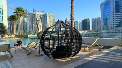 a bird cage sitting next to a pool in a city at Bellaviu Holiday Homes Peaceful Escape at DAMAC Maison Prive in Dubai