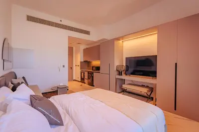 a bedroom with a large bed and a television at Voyage Studio In Mag City in Dubai