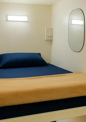 a bedroom with a bed and a mirror at Devine Homes JBR Hostel in Dubai