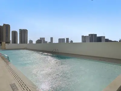 a swimming pool with a city skyline in the background at Chic Studio with Balcony and Gym at JVC in Dubai