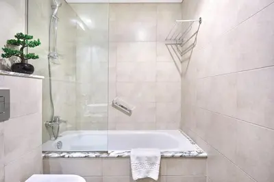 a bathroom with a tub and a toilet and a shower at Aykon City 2BR Luxury Stay Close to Downtown in Dubai