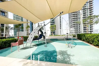 a playground with a slide and two chairs at LUX The Marina Vista Beachfront Suite 5 in Dubai