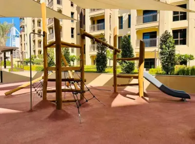 a playground in front of a building with a slide at Vogue Madinat Jumeirah Living Jadeel near Burj AlArab, One-Bedroom Apartment with Large Balcony and Pool View, Access to All Amenities in Dubai