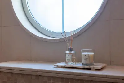 two candles sitting on a table under a window at Elite Villa in Dubai in Dubai