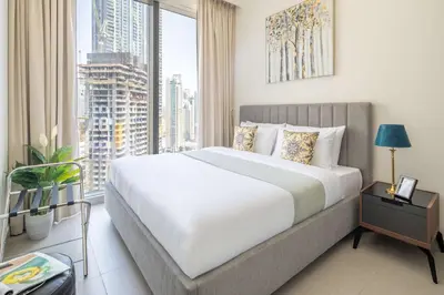 a bedroom with a large bed and a large window at Frank Porter - Forte Tower 1 in Dubai
