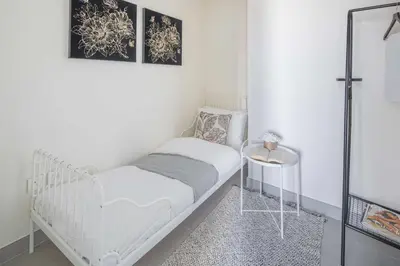 a white room with a crib and a table at Frank Porter - Forte Tower 1 in Dubai