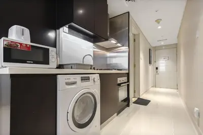 a kitchen with a washing machine and a sink at studio in downtown Damac upper crest next to dubai mall in Dubai