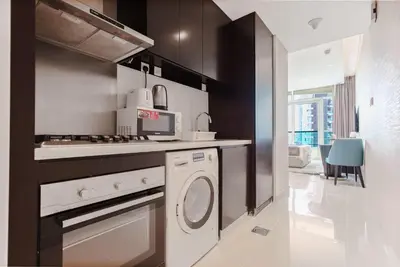 a kitchen with a washer and dryer in it at studio in downtown Damac upper crest next to dubai mall in Dubai