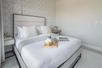 a bedroom with a large white bed with a tray on it at Frank Porter - Kappa Acca 3 in Dubai