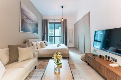 a living room with a bed and a couch at HAVN - Studio in La Riviera Azure JVC, Pool View in Dubai