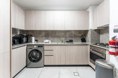 a kitchen with a washer and a dishwasher at HAVN - Studio in La Riviera Azure JVC, Pool View in Dubai