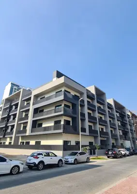 a large building with cars parked in front of it at HAVN - Studio in La Riviera Azure JVC, Pool View in Dubai