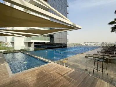 a swimming pool in front of a building at Damac Hills Carson A Monthly Stay - Pay 28, Stay 30 in Dubai