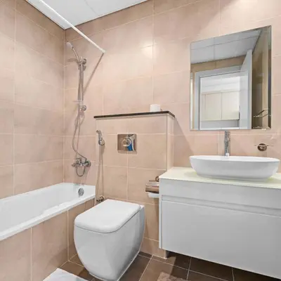 a bathroom with a toilet and a sink and a mirror at Damac Hills Carson A Monthly Stay - Pay 28, Stay 30 in Dubai