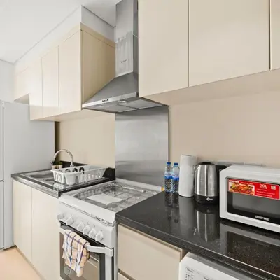 a kitchen with a stove and a microwave at Damac Hills Carson A Monthly Stay - Pay 28, Stay 30 in Dubai