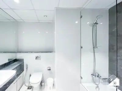 a bathroom with a shower and a toilet and a sink at Business Bay 2BR in Amna Tower & Canal Views in Dubai
