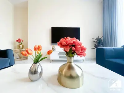 two vases with flowers on a table in a living room at Business Bay 2BR in Amna Tower & Canal Views in Dubai